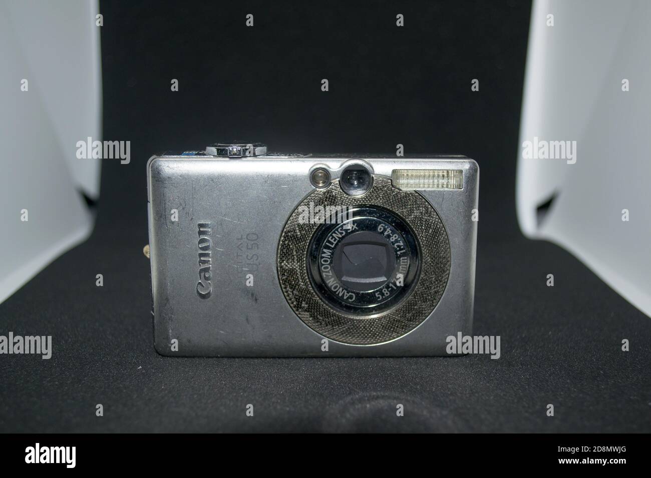 An old functioning Canon IXUS 50 digital camera isolated in a black and white background Stock Photo