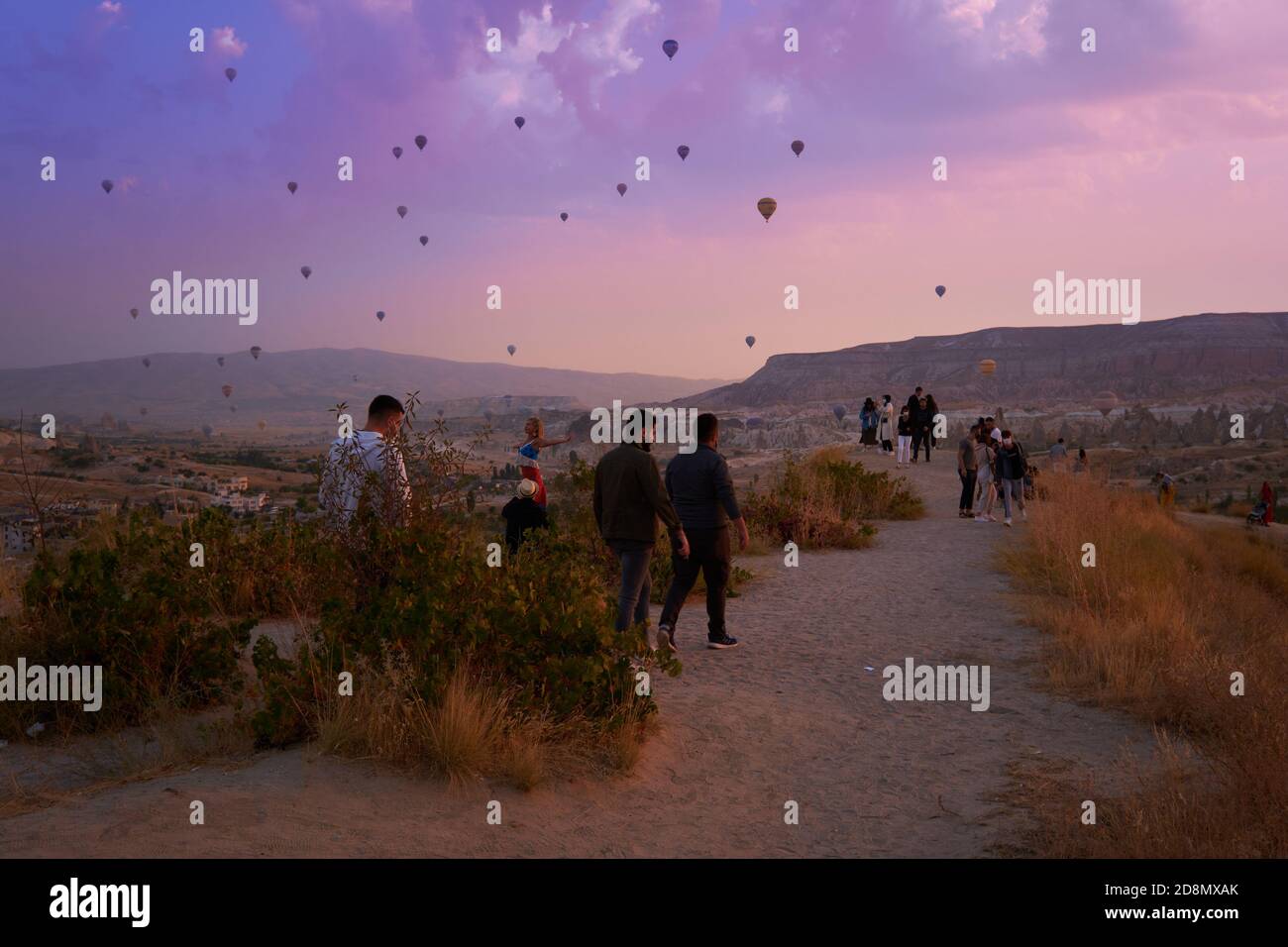 Tourists walk to the Goreme viewpoint to see hot air balloons, Cappadocia Stock Photo