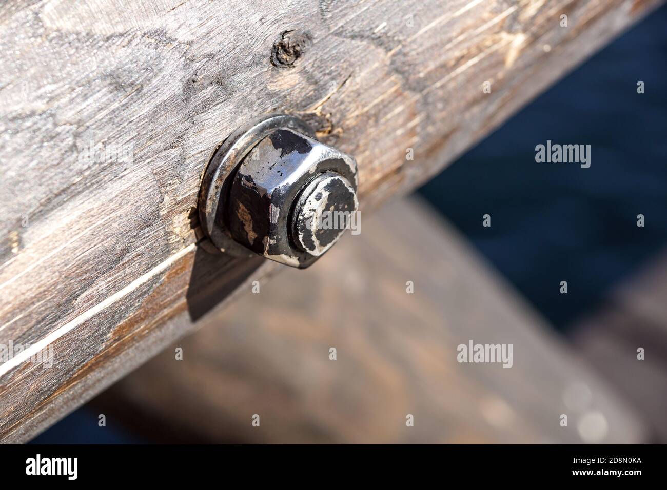 Nut and bolt on a wooden background. Close up detail. Stock Photo