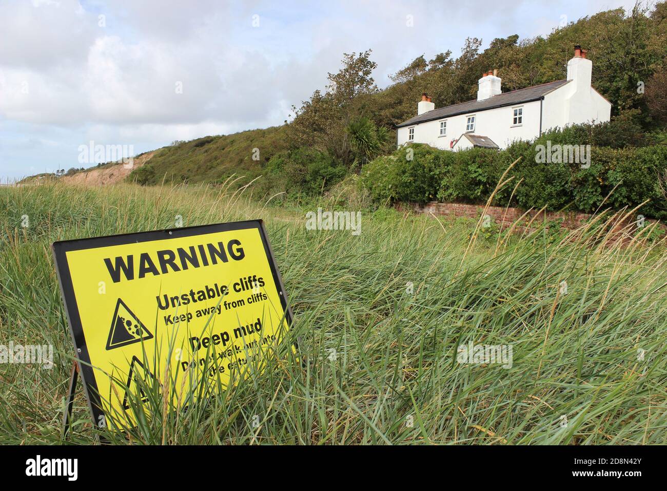 Shore Cottage and Unstable Cliffs Warning Sign, Thurstaston, Wirral, UK Stock Photo
