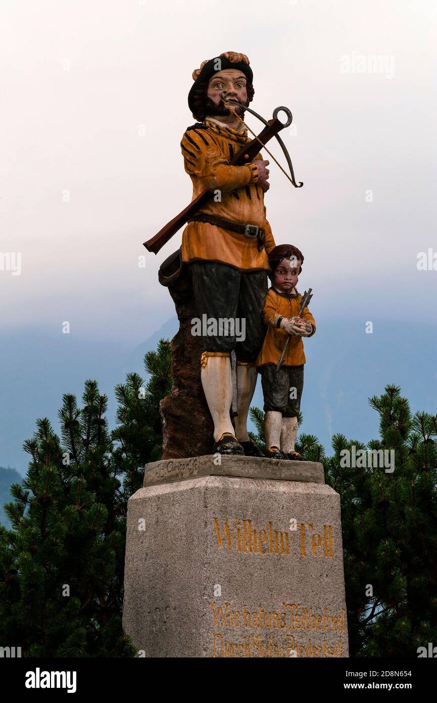 Wilhelm (William) Tell, Swiss national hero, symbol of freedom and expert marksman, holds his crossbow as his young son, Walter, clutches an apple pierced by his father’s arrow in this late-18th century statuary group by Swiss sculptor Joseph Benedikt Curiger or Kuriger at Bürglen, Uri canton, Switzerland.  Tell is said to have shot the apple from Walter’s head, saving them both from execution, in 1307 at nearby Altdorf.  However, he is said to have lived at Bürglen and a 16th century chapel on the reputed site of his birthplace is frescoed with his life story. Stock Photo