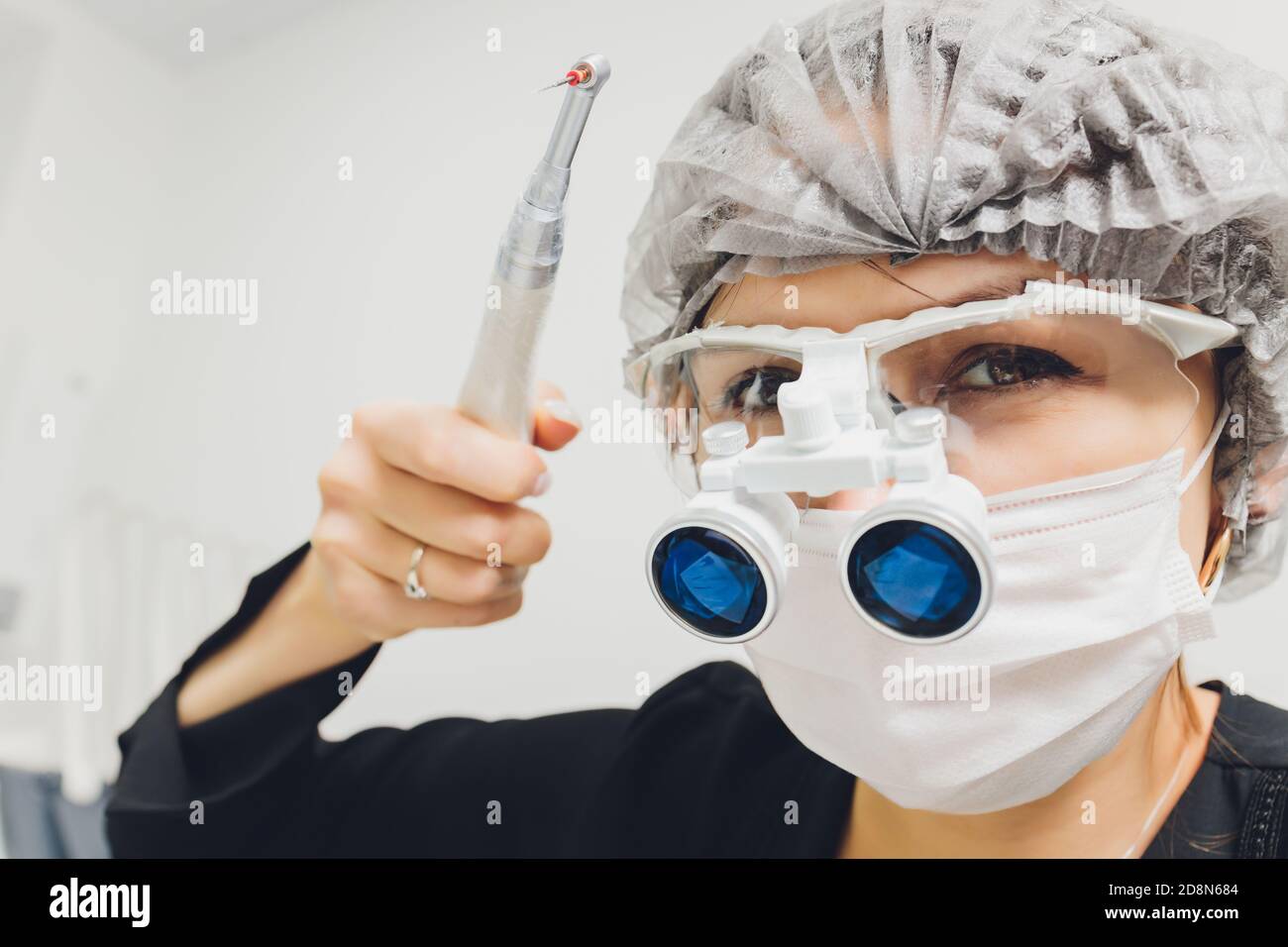feMale dentist in special glasses with magnifying glasses and mask