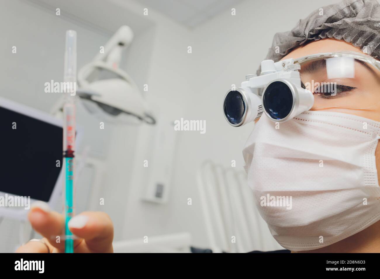 feMale dentist in special glasses with magnifying glasses and mask