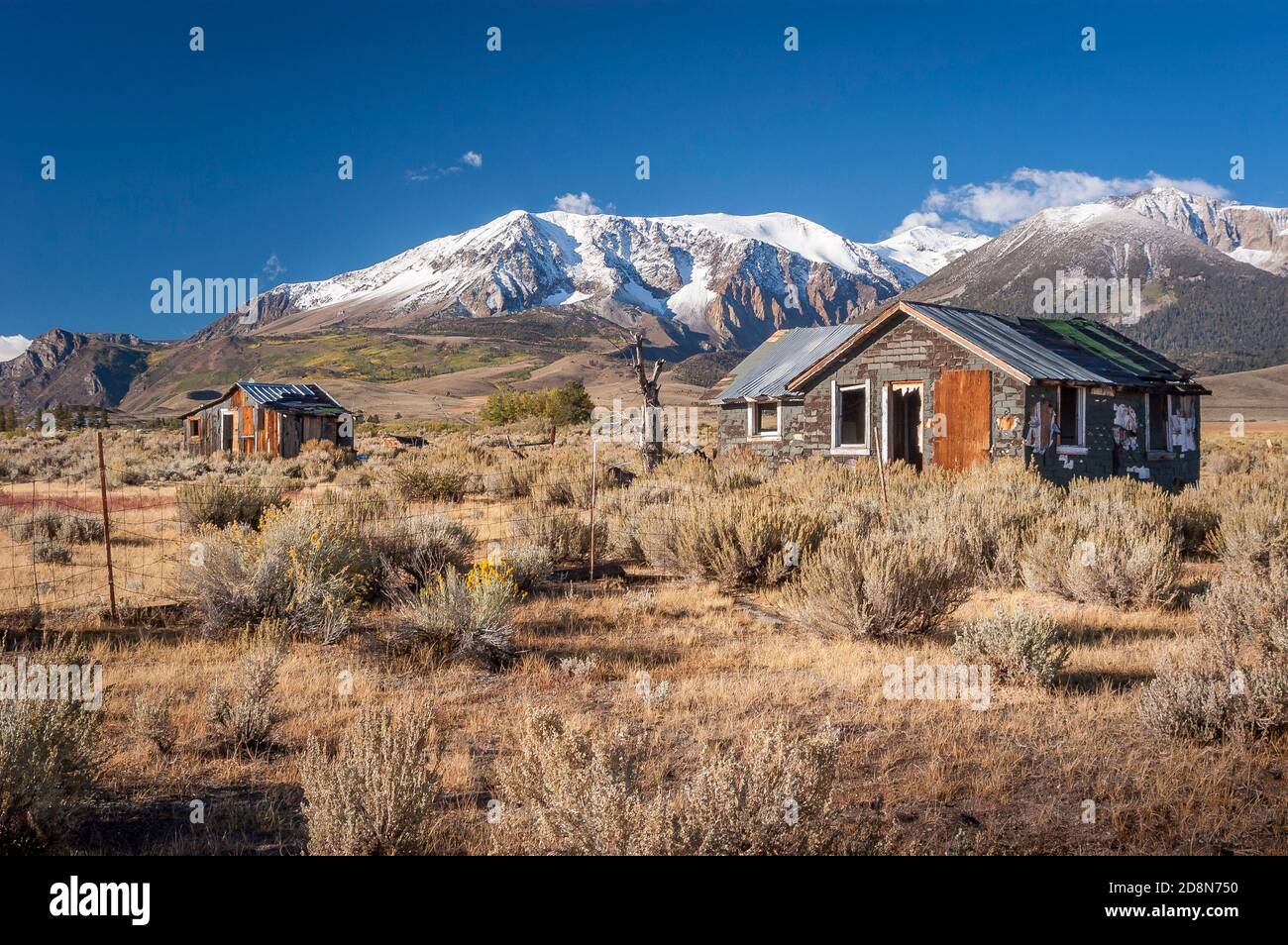 An abandoned homesite in the Owens Valley of California with the snow covered Sierra Nevada mountain range in the background. Stock Photo