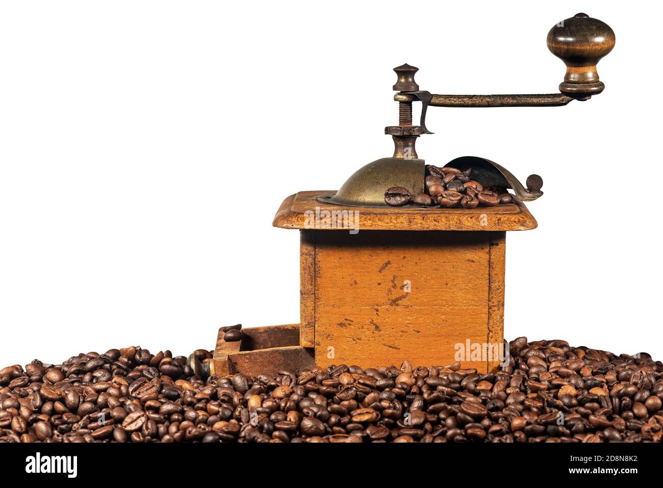 Old manual coffee grinder made of metal and wood with roasted coffee