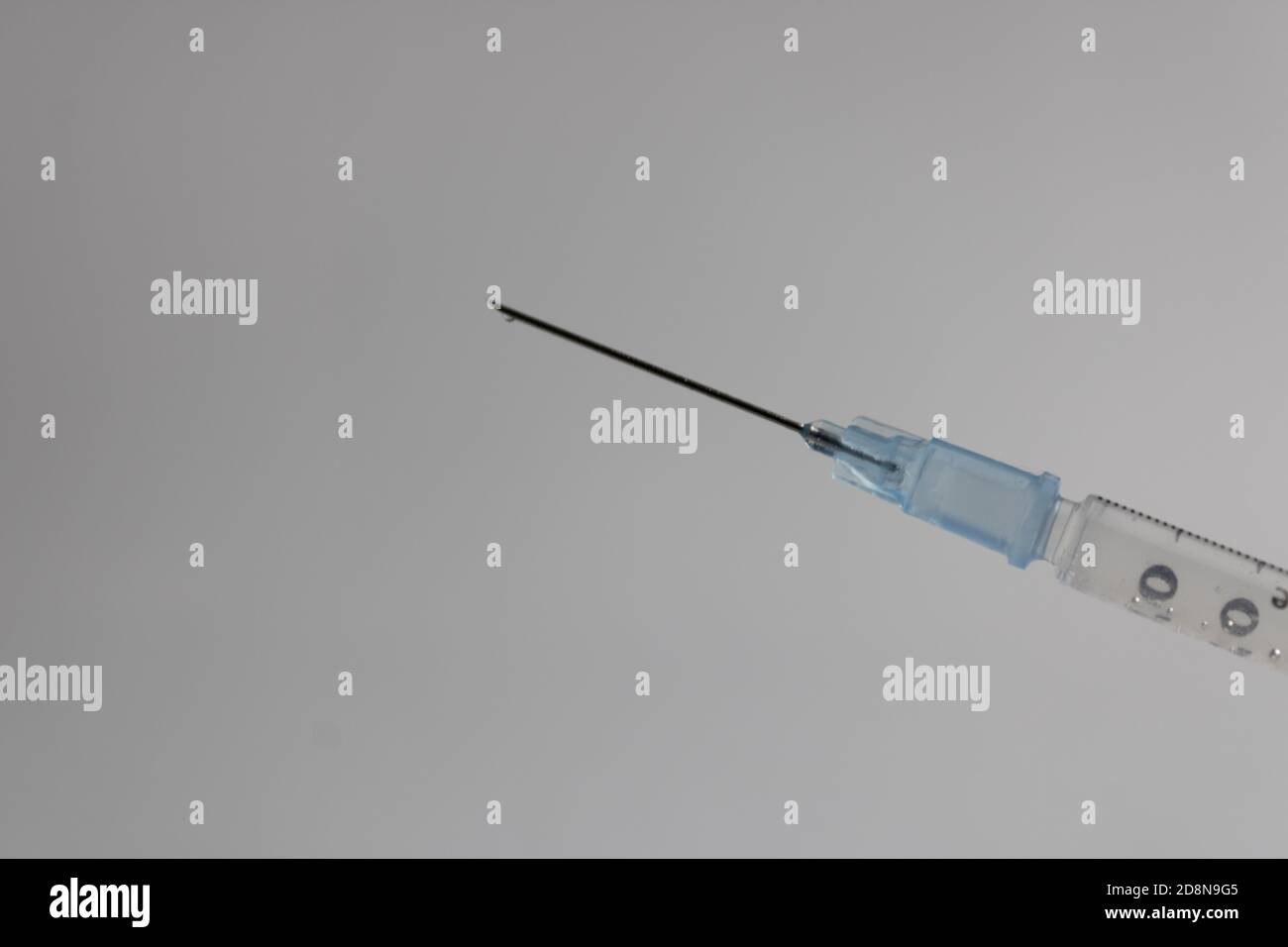syringe needle with a drop of medicine at the tip, checking for air