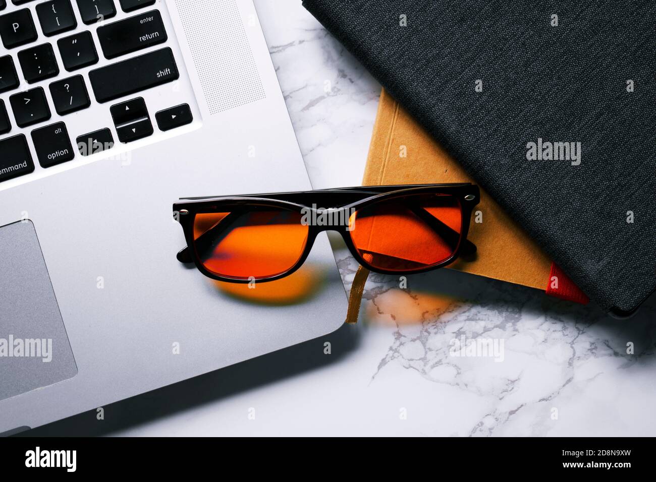 View of Desk with laptop, notebook, tablet, and blue light-blocking glasses ...