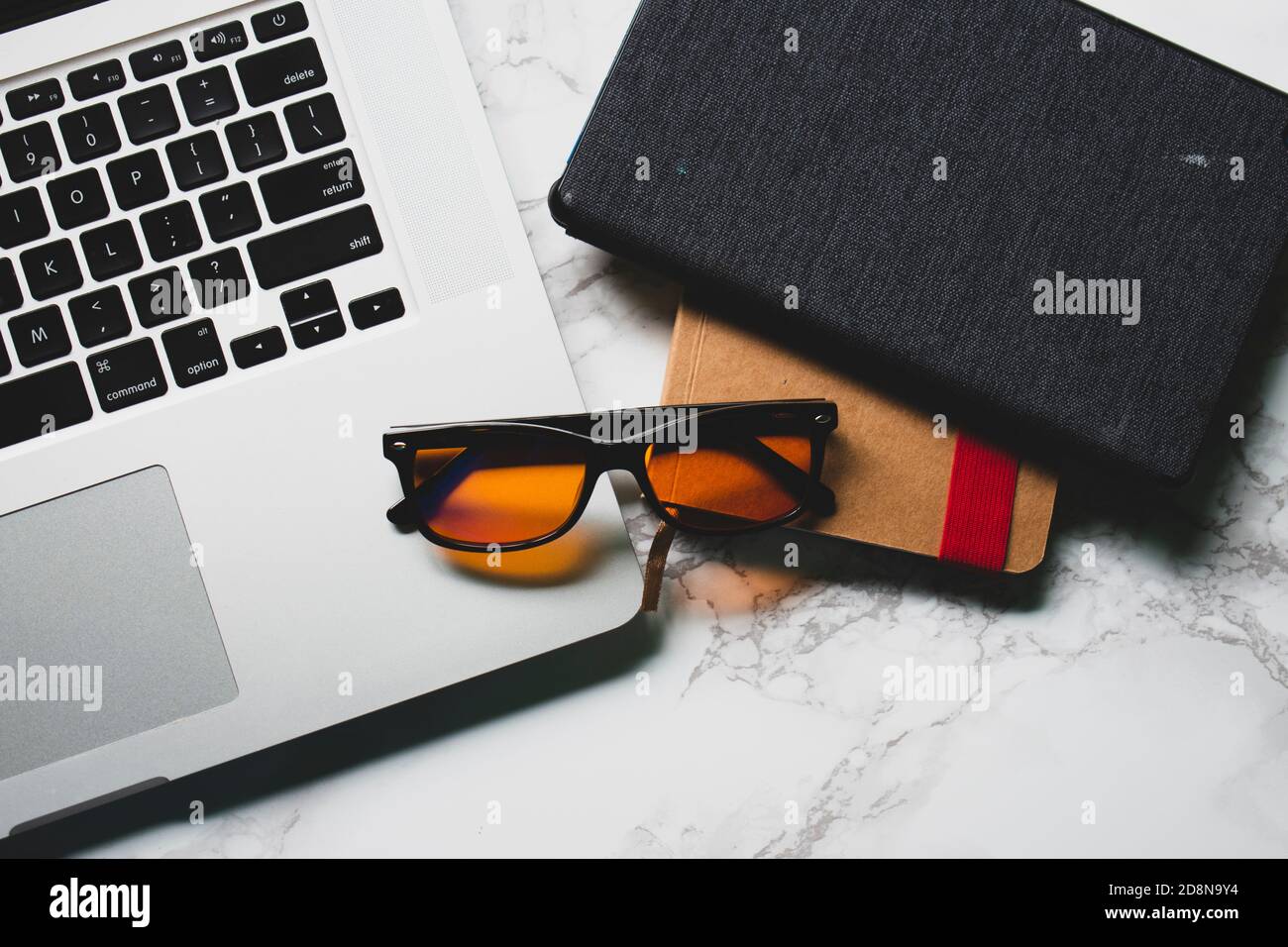 Picture of Desk with laptop, notebook, tablet, and blue light-blocking glasses ...
