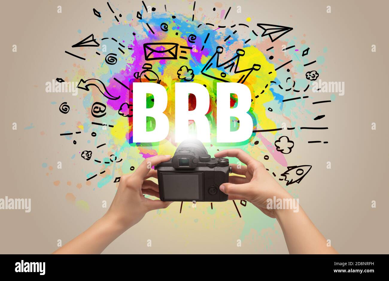 Close-up of a hand holding digital camera with abstract drawing and BRB inscription Stock Photo