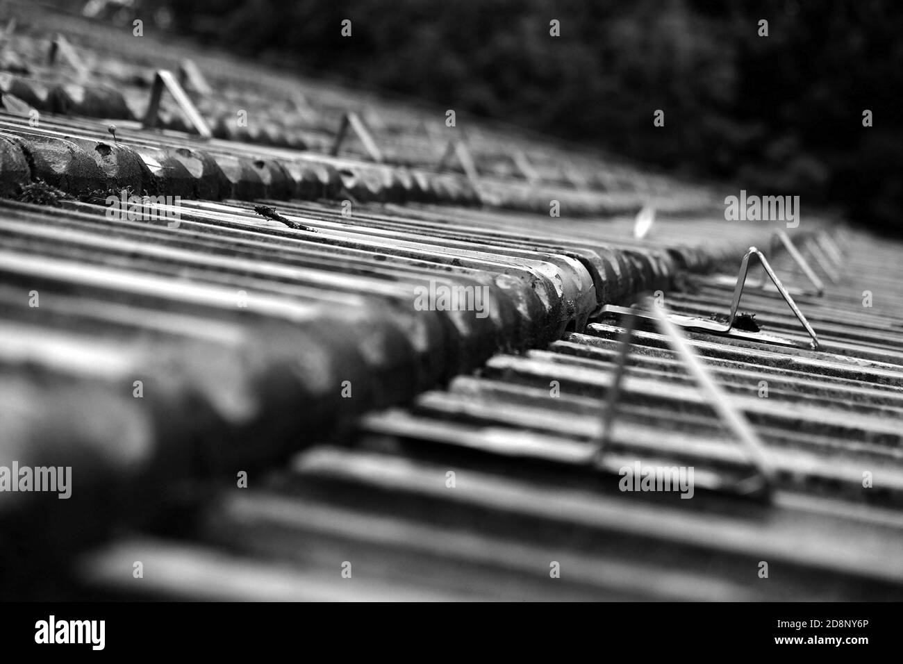 Grayscale shot of a detail of roof tiles with metal brackets Stock Photo