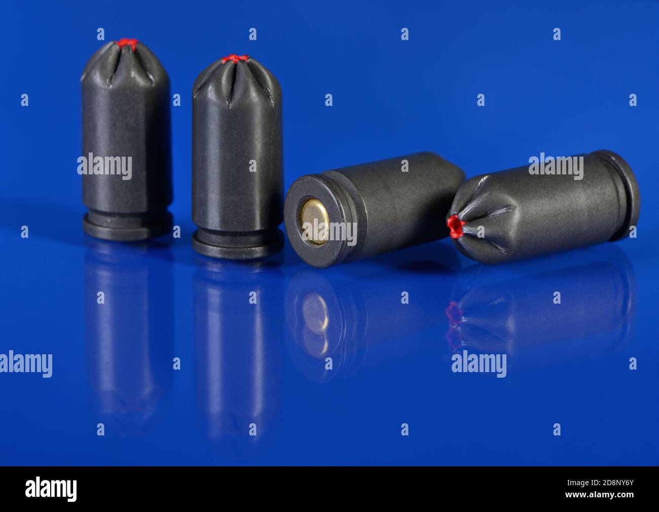 Four blank cartridges for pistol on blue background closeup Stock