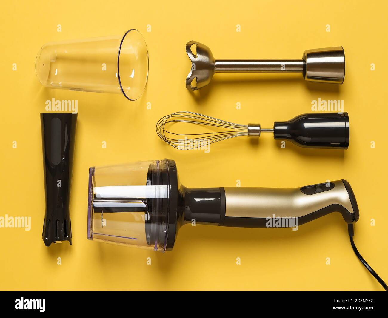 Immersion hand blender with different attachments and cups knolled on a