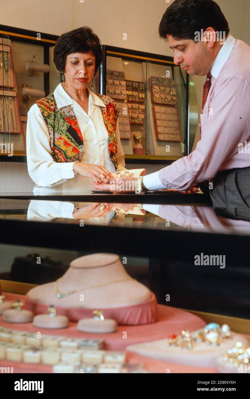 Jewelry store owner is showing a ring to female customer, USA Stock