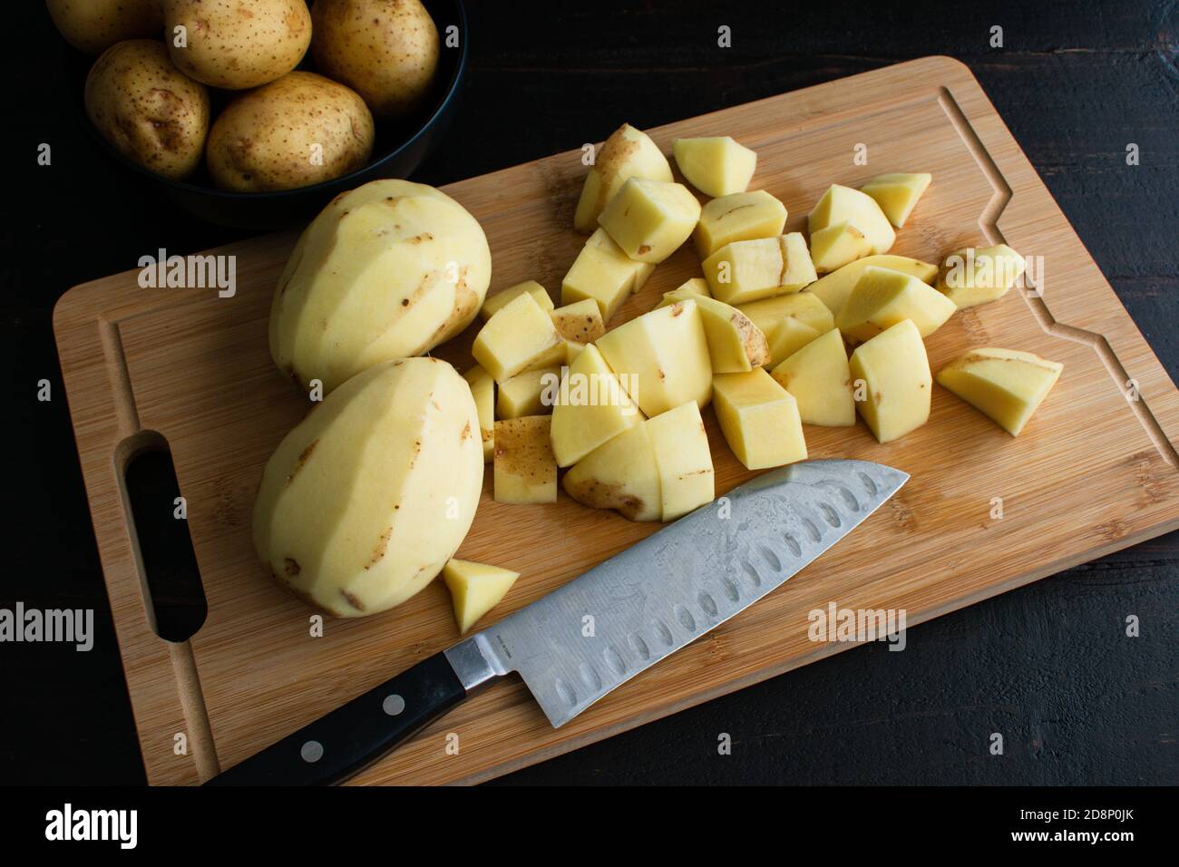 Premium Photo  Slicing organic gold potatoes on a v-blade