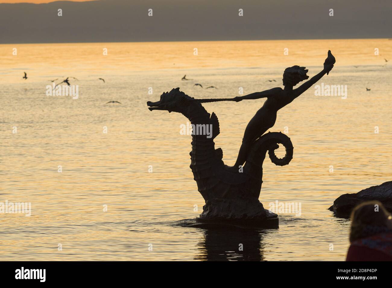 Statue of a Young Girl Holding a Shell and Riding a Seahorse Hippocampus in front of Lake Geneva in Vevey, Switzerland Stock Photo