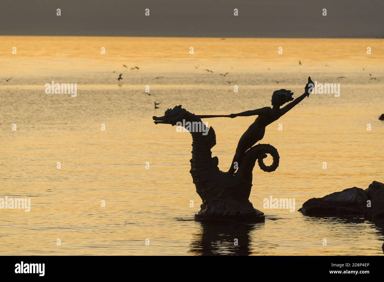 Statue of a Young Girl Holding a Shell and Riding a Seahorse Hippocampus in front of Lake Geneva in Vevey, Switzerland Stock Photo