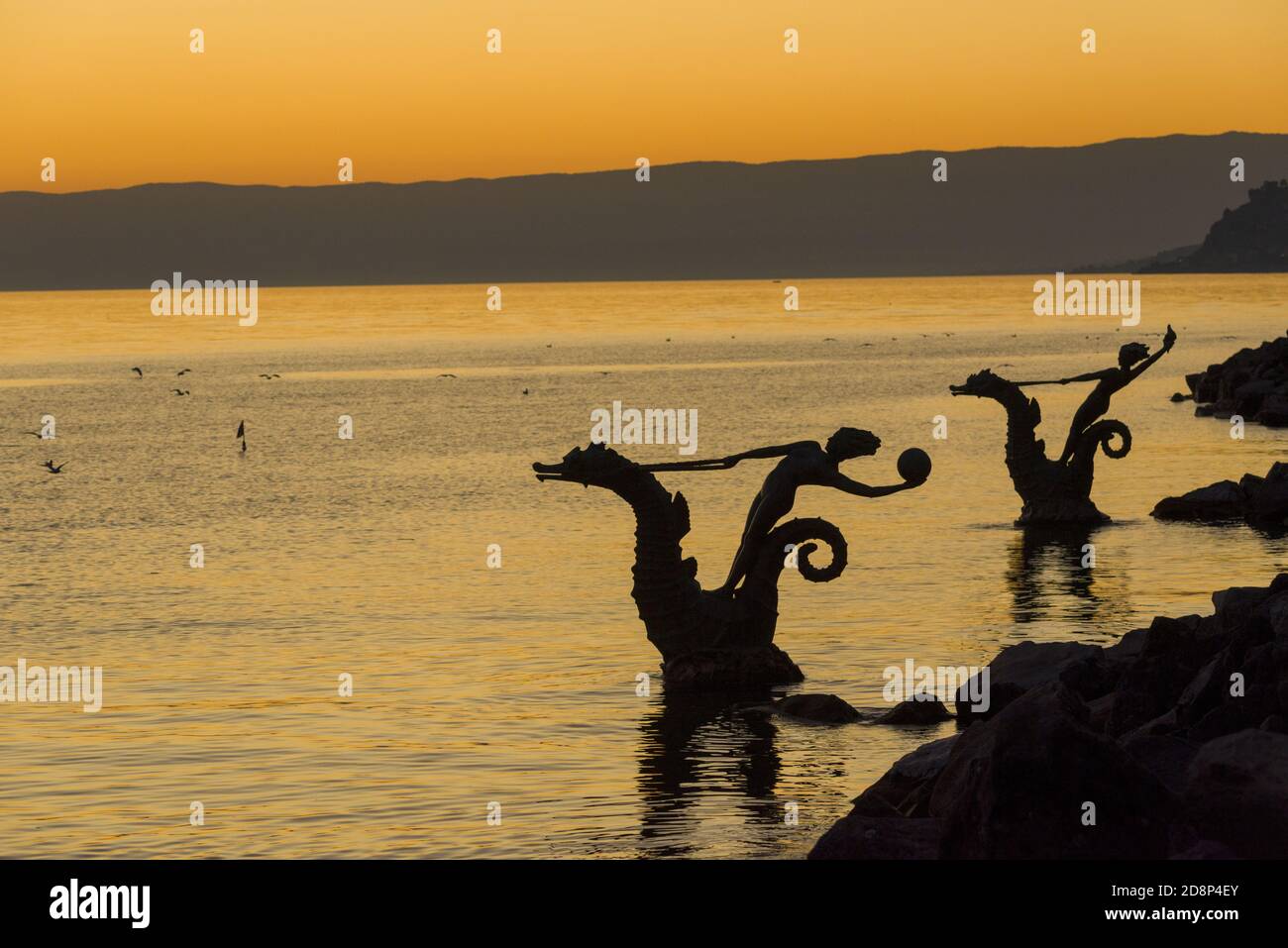 Statue of a Young Girl Holding a Shell and Riding a Seahorse Hippocampus in front of Lake Geneva in Vevey, Switzerland Stock Photo