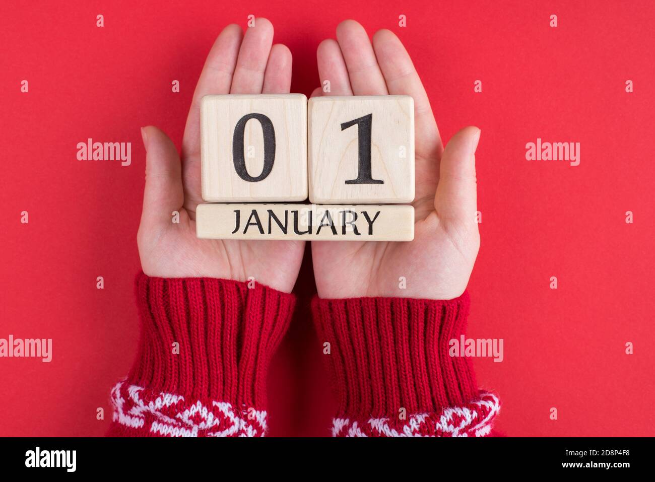 First day of happy new year concept. Top above overhead close up view photo of female hands holding calender with the first of january isolated over b Stock Photo