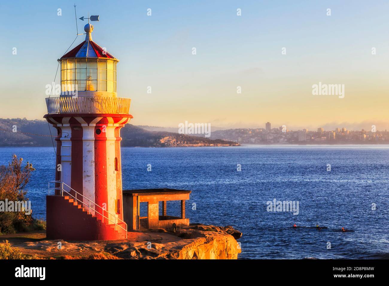 Historic red-white stripped Hornby lighthouse at the entrance to Sydney harbour facing rising sun. Stock Photo