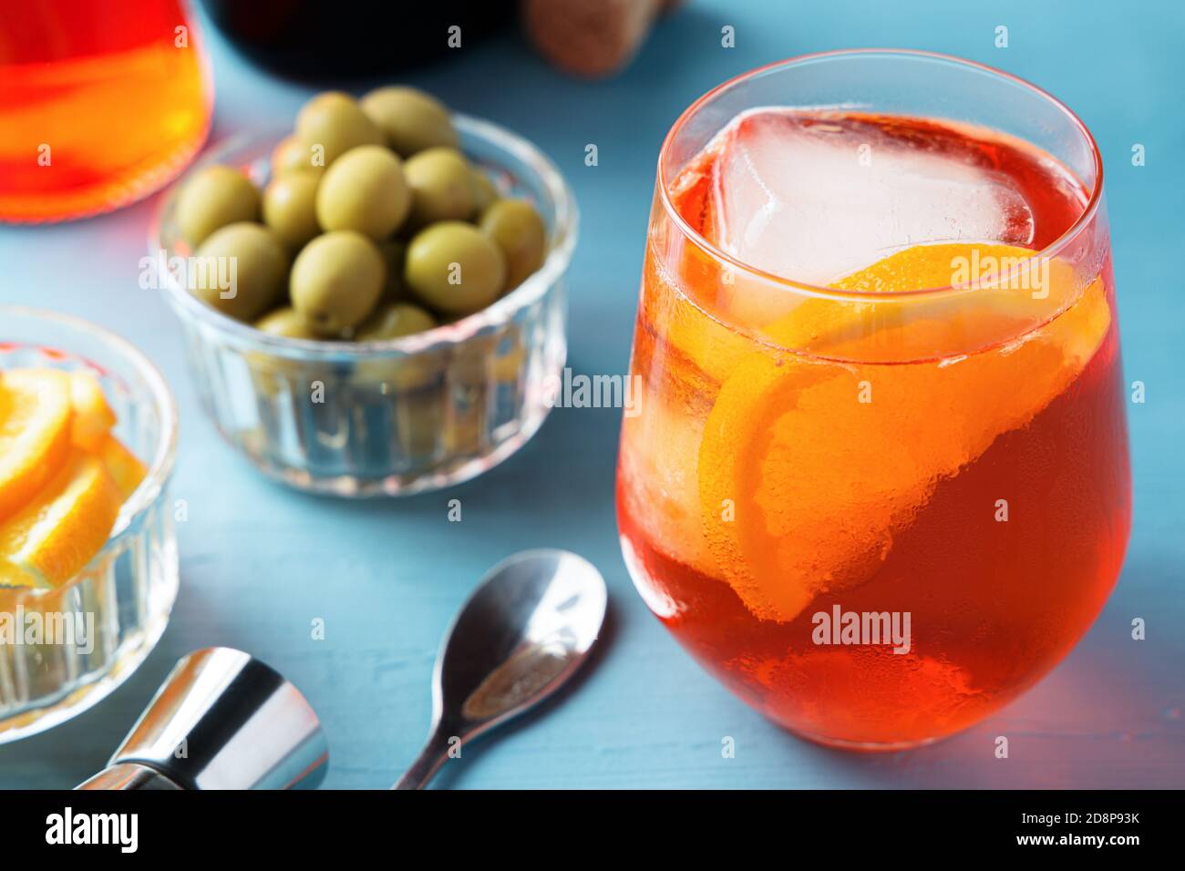 Glass of cold spritz cocktail with some olives on blue table Stock Photo