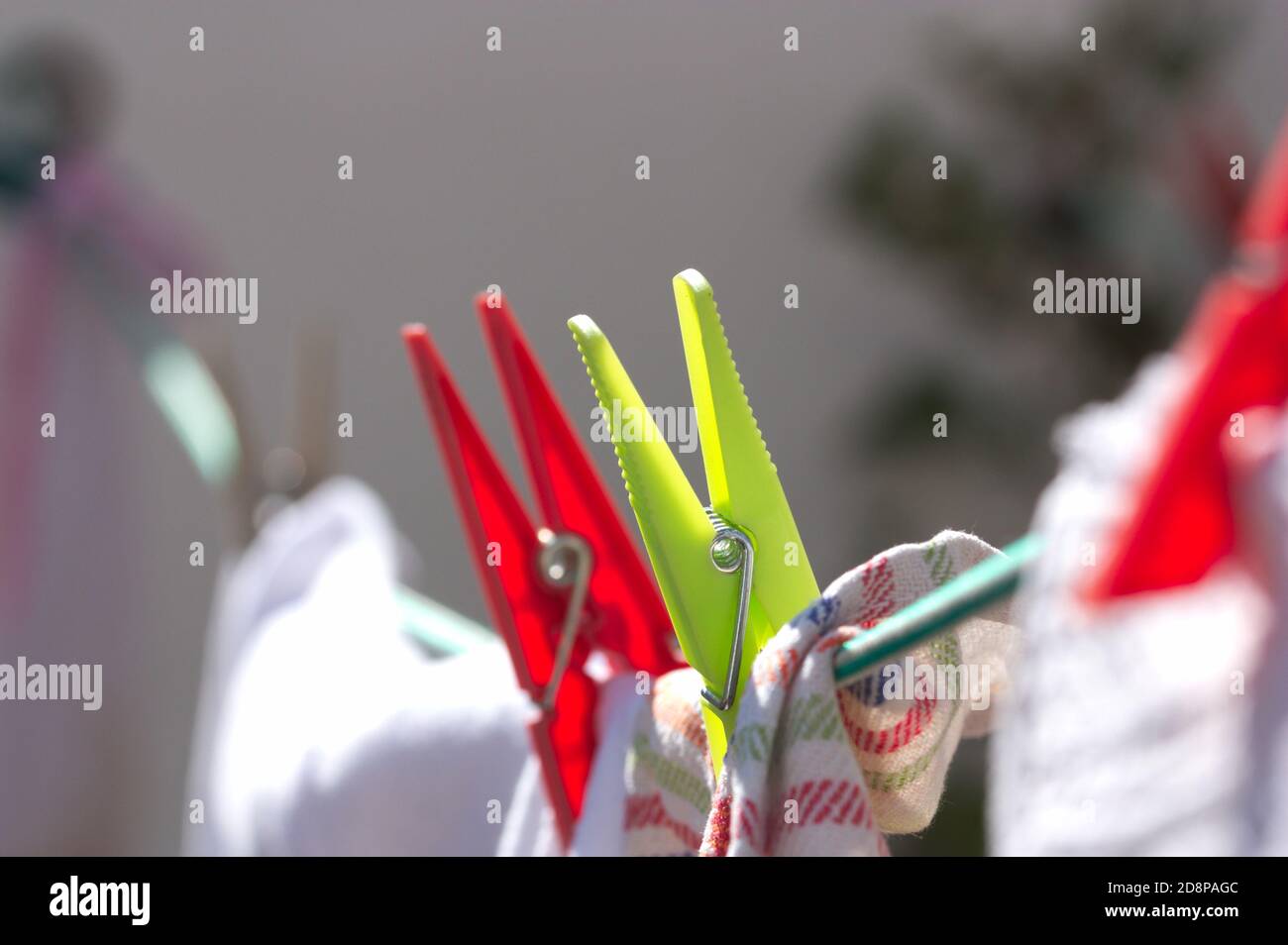Closeup of clothespins that hold home clothes hanging on a rope to dry