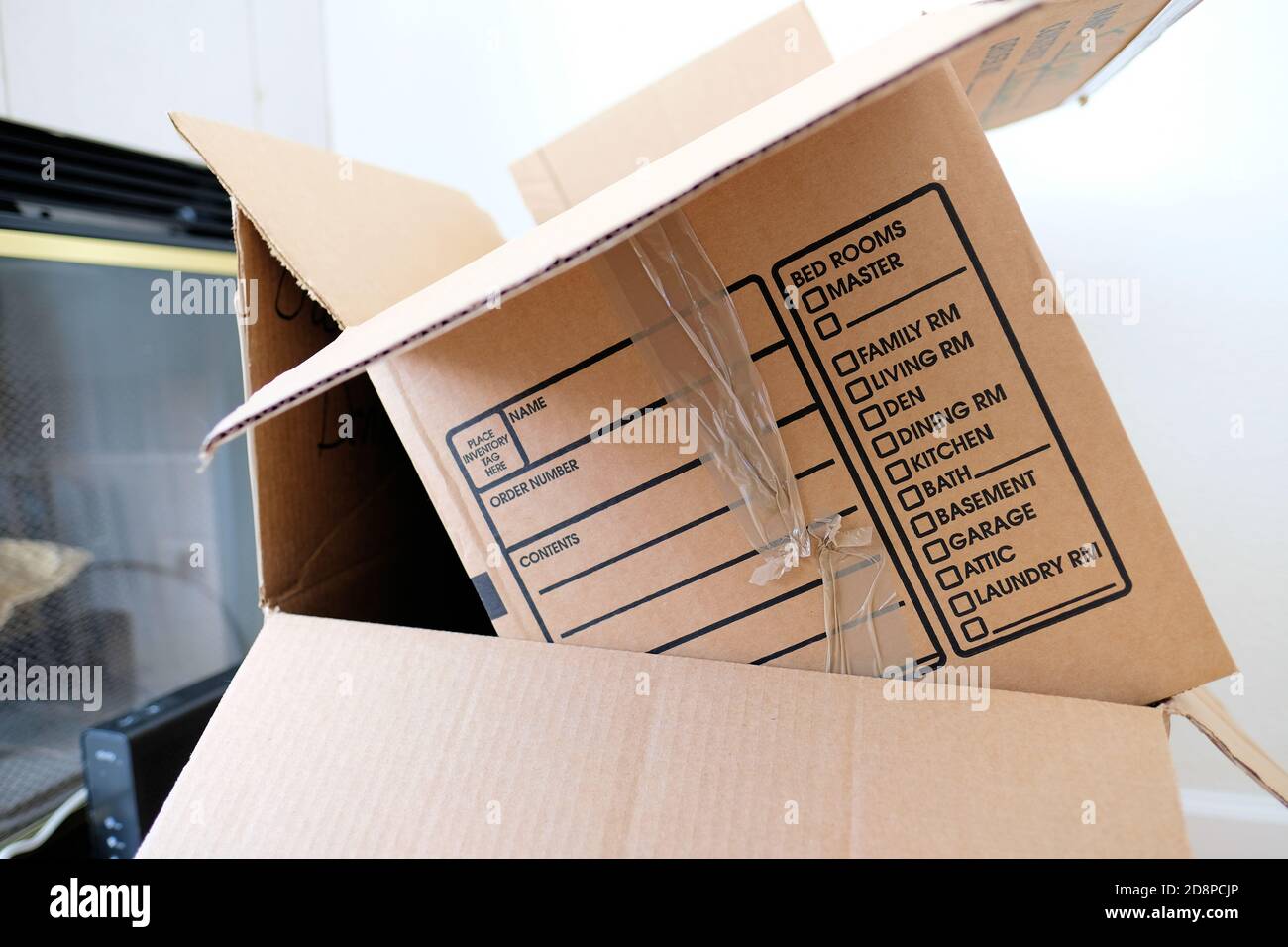 Moving cardboard boxes with printed list of items for each room bed