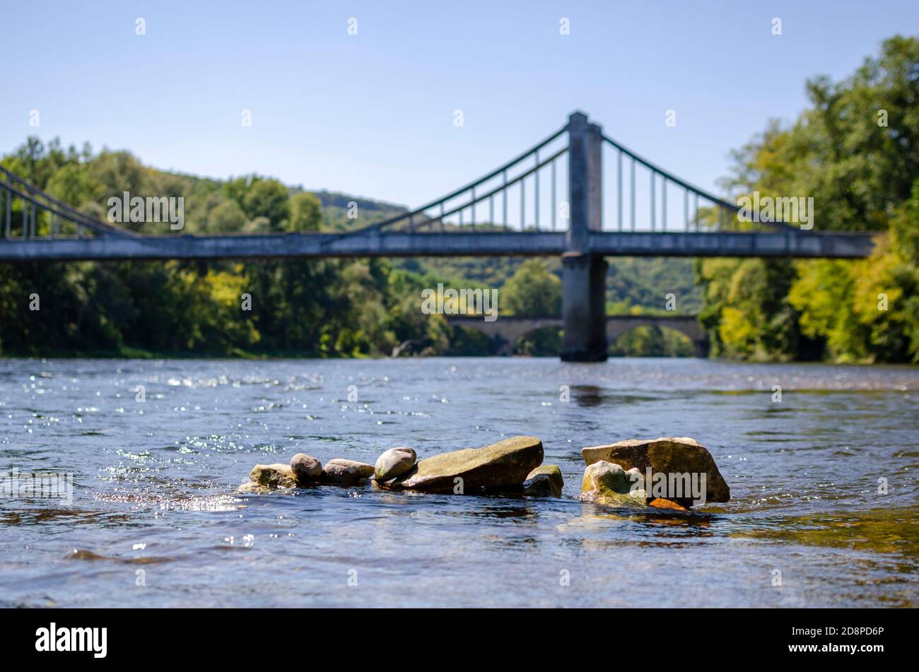 bridge over a river with some rocks in the foreground Stock Photo