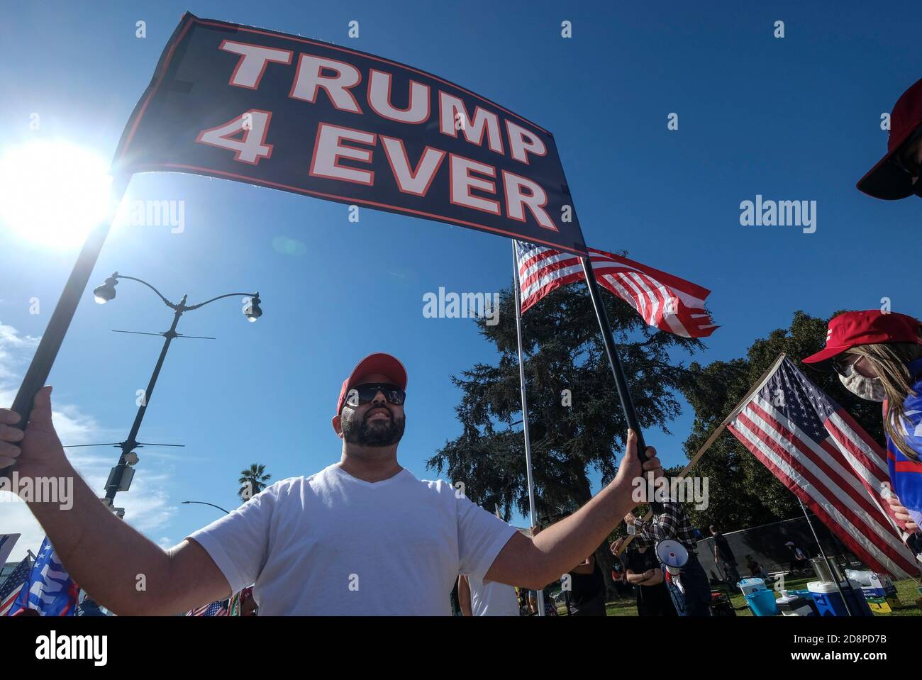 Los Angeles, California, USA. 31st Oct, 2020. People hold signs and ...