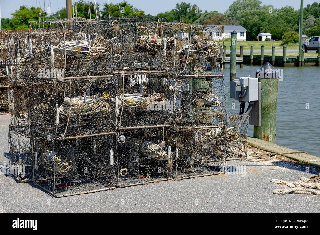 Crab pots stacked on a marina dock before loading onto a fishing boat
