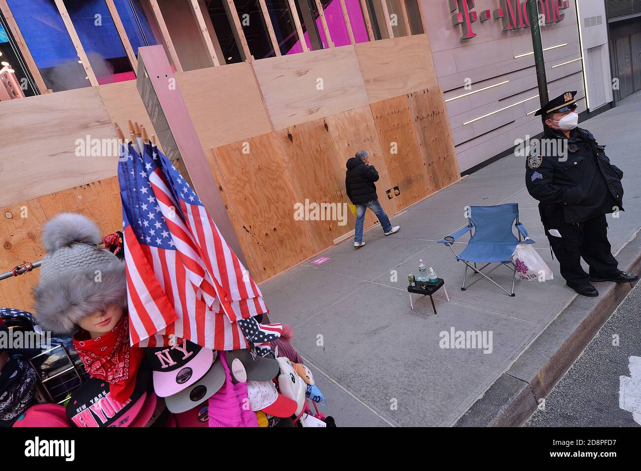 New York City, USA. 31st Oct, 2020. A pedestrian walks past the boarded up windows of T-Mobile Times Square store in New York, in New York, NY October 31, 2020. Oct. 31, 2020. With a contentious Presidential Election a few days away, some stores are preparing for a what could be another round of vandalism such what they experienced over this past summer. (Anthony Behar/Sipa USA) Credit: Sipa USA/Alamy Live News Stock Photo