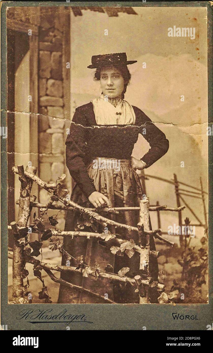 Vintage cabinet card shows woman posing in a photo graphic studio. Photo was taken in Austro-Hungarian Empire or also Austro-Hungarian Monarchy Stock Photo