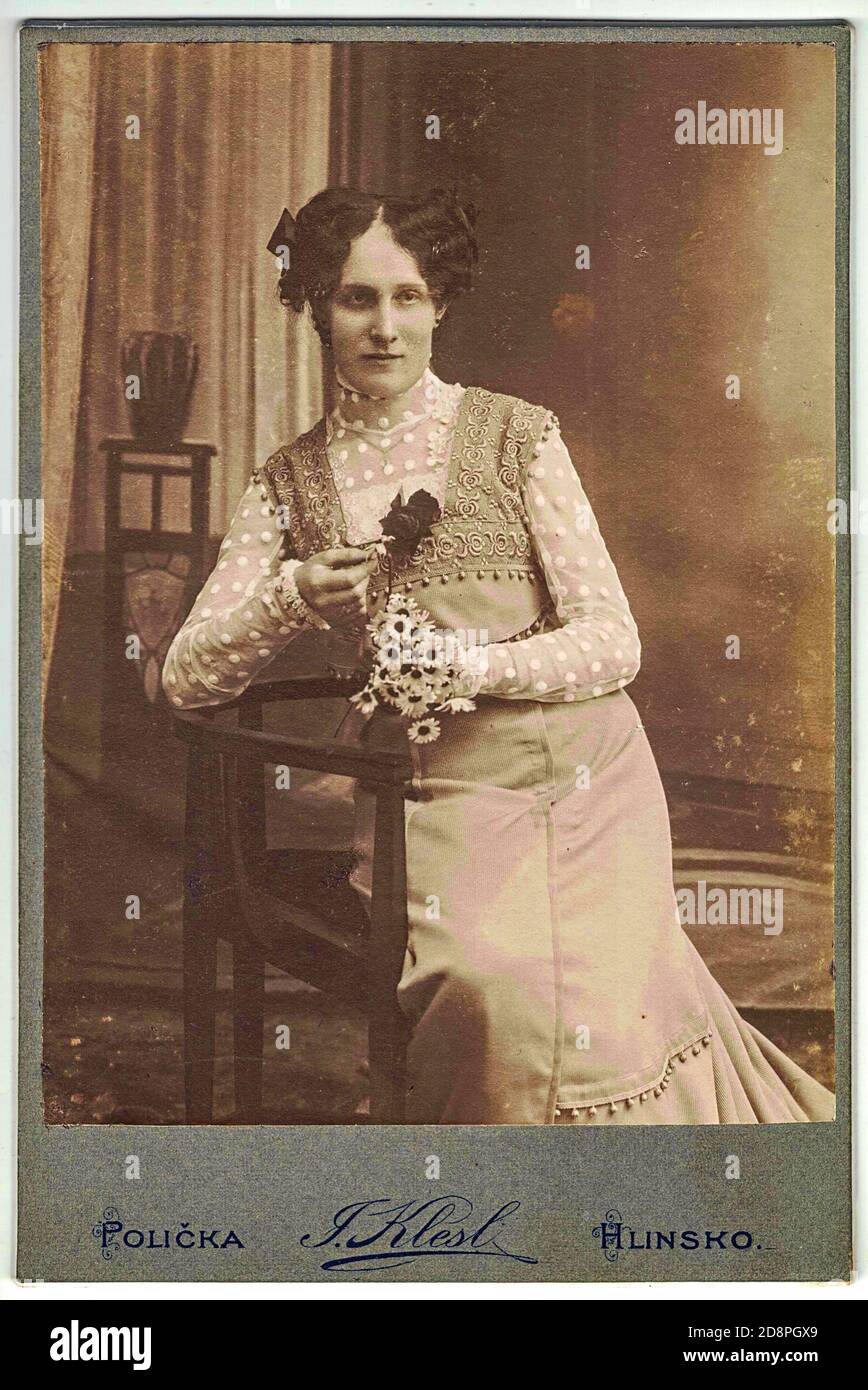 Vintage cabinet card shows woman posing in a photo graphic studio. Photo was taken in Austro-Hungarian Empire or also Austro-Hungarian Monarchy Stock Photo