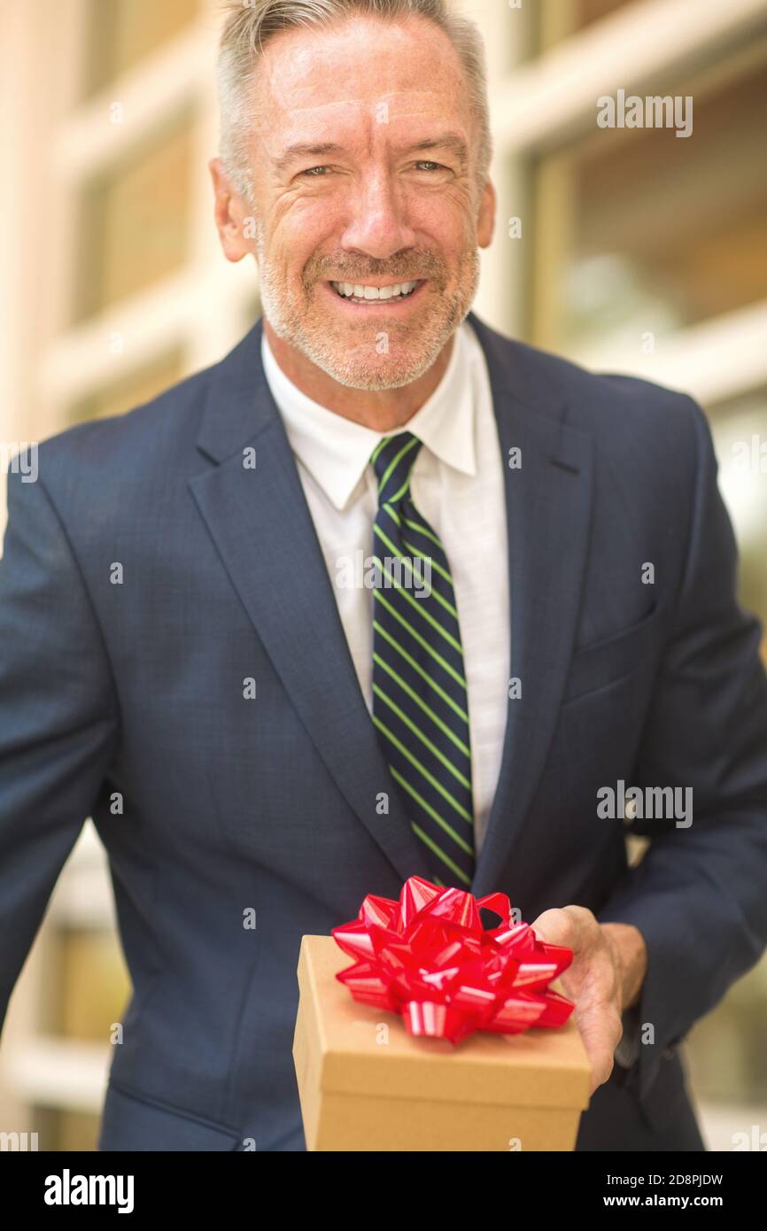 Mature handsome man giving a gift stock photo Stock Photo - Alamy