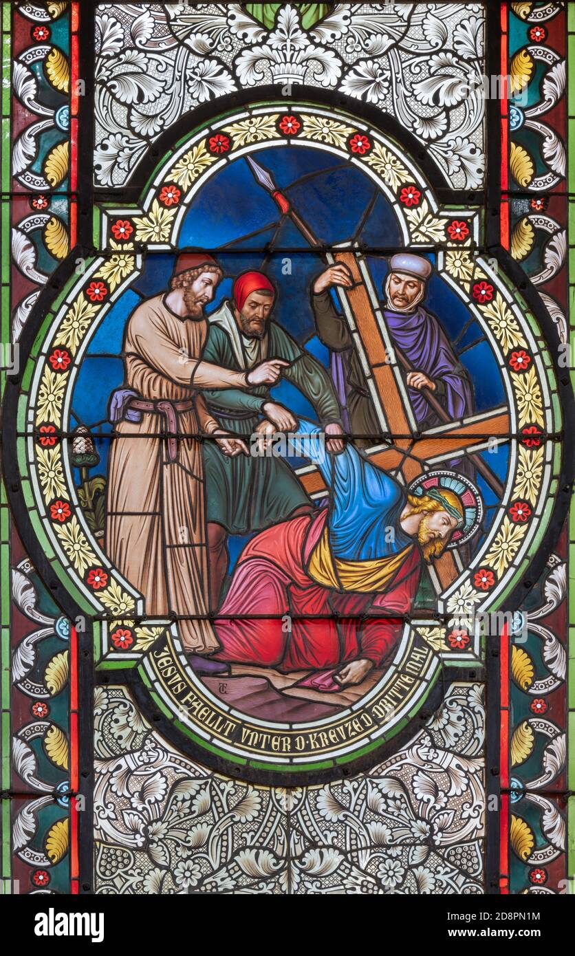 VIENNA, AUSTIRA - OCTOBER 22, 2020: The Fall of Jesus under the cross on the stained glass in church Pfarrkirche Kaisermühlen. Stock Photo