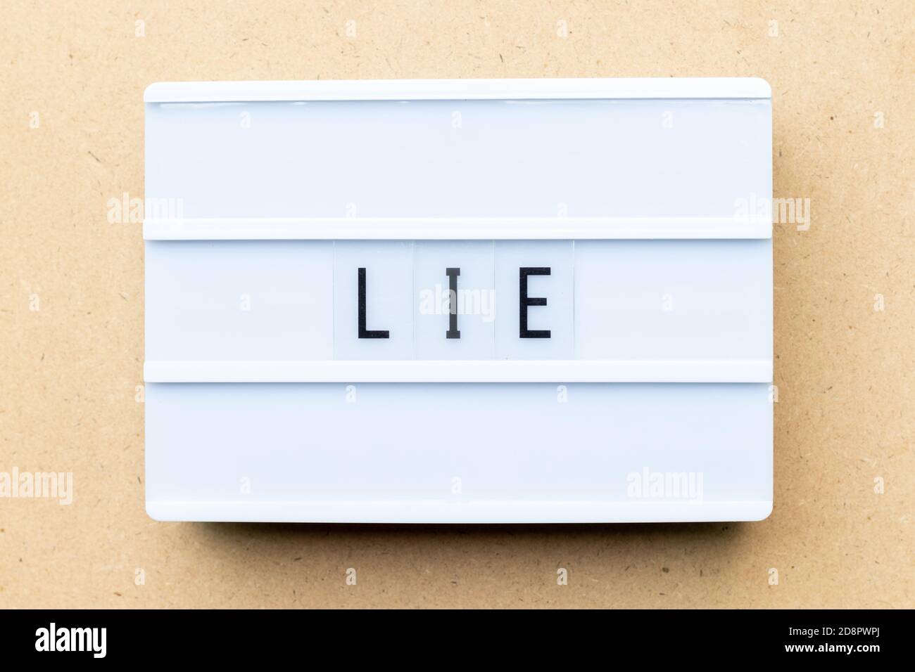 White lightbox with word lie on wood background Stock Photo