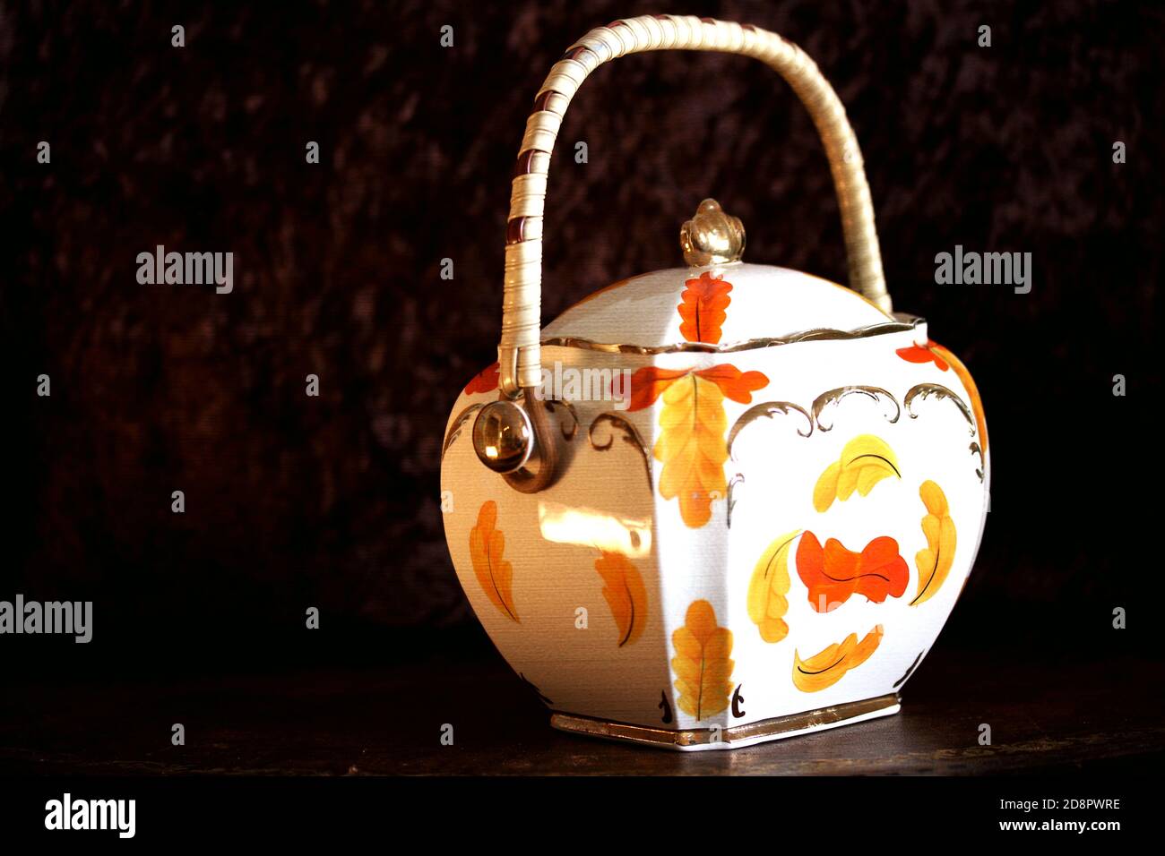 Closeup of a vintage sugar pot with a floral design against a black