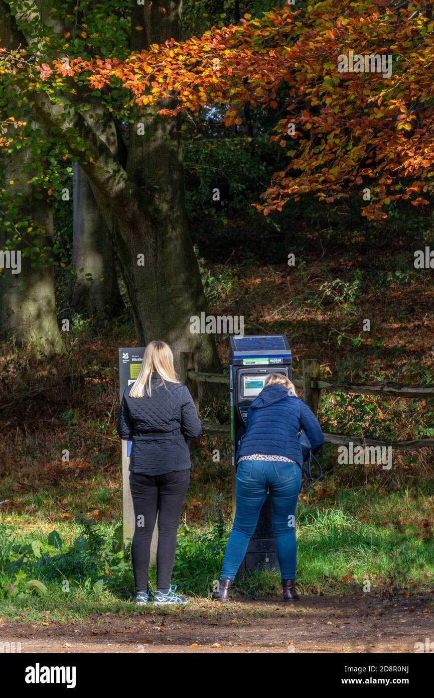 two women buying a parking ticket from a machine at a national trust