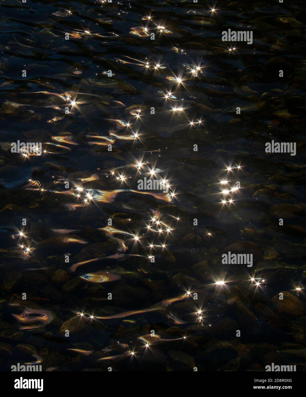 Sunlight reflected on rippling water.  Design made by stars on water. Stock Photo