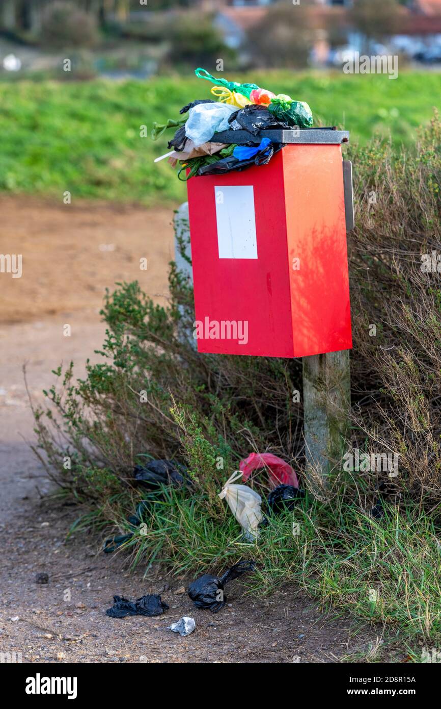 overflowing dog mess bin in need of emptying by local authority or council. dog walkers disposing of poo and mess in dedicated specific receptacle Stock Photo