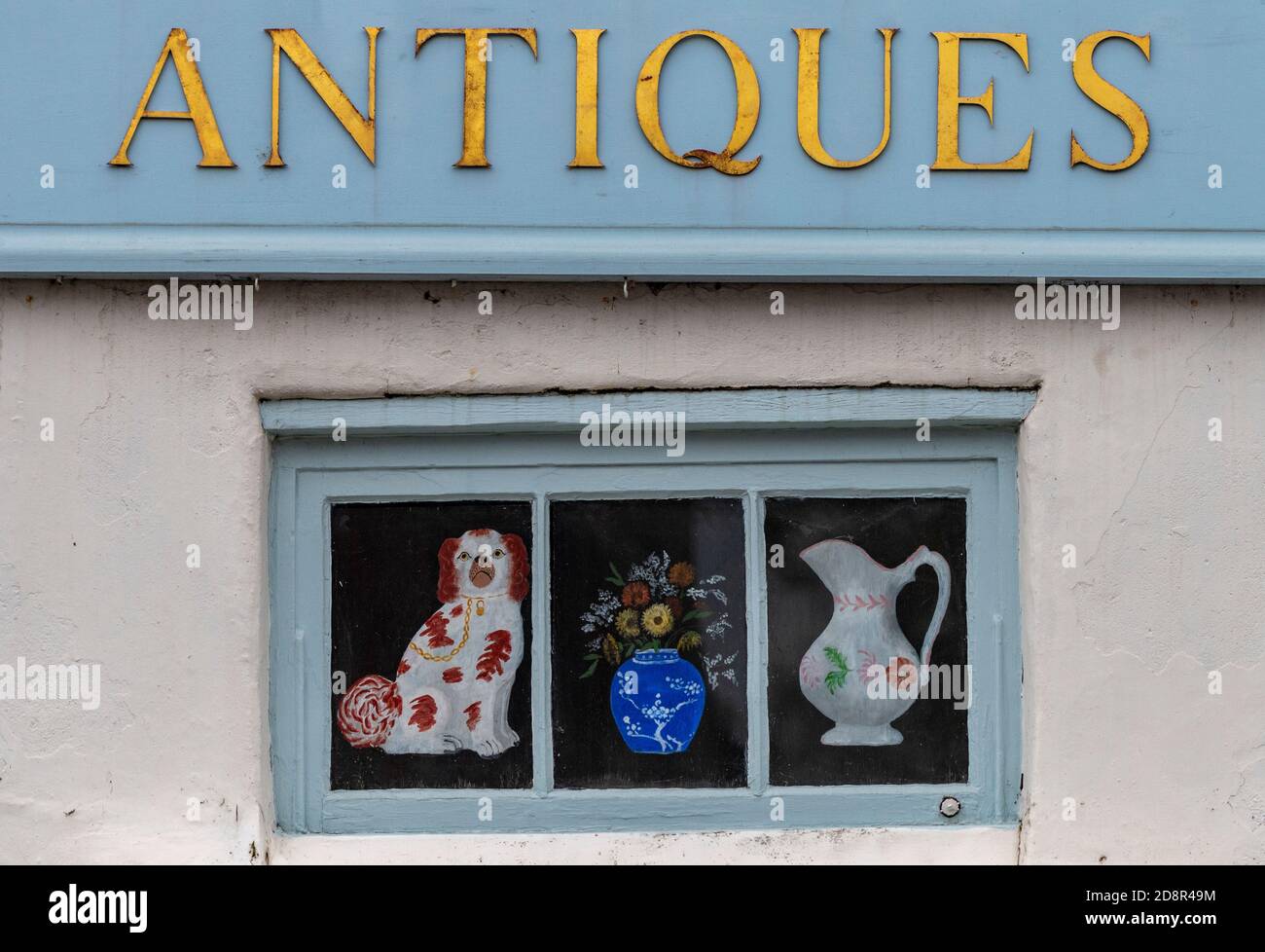 the sign above the door of a traditional antiques shop in holt, norfolk
