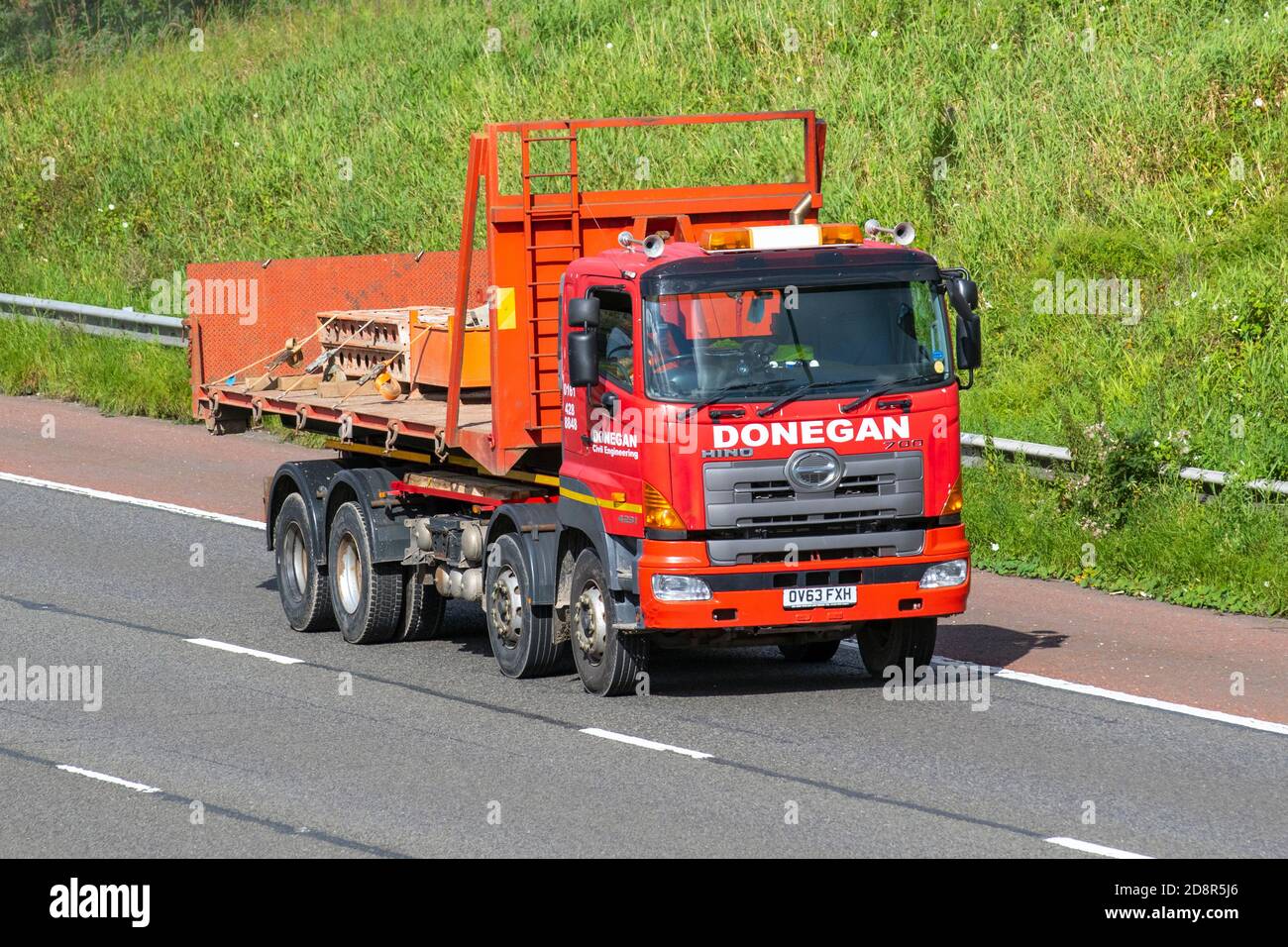 2013 red Hino 700 Series; Donegan Haulage delivery trucks, lorry, heavy-duty vehicles,transportation, diesel truck, cargo carrier, vehicle, European commercial transport industry HGV, M61 at Manchester, UK Stock Photo