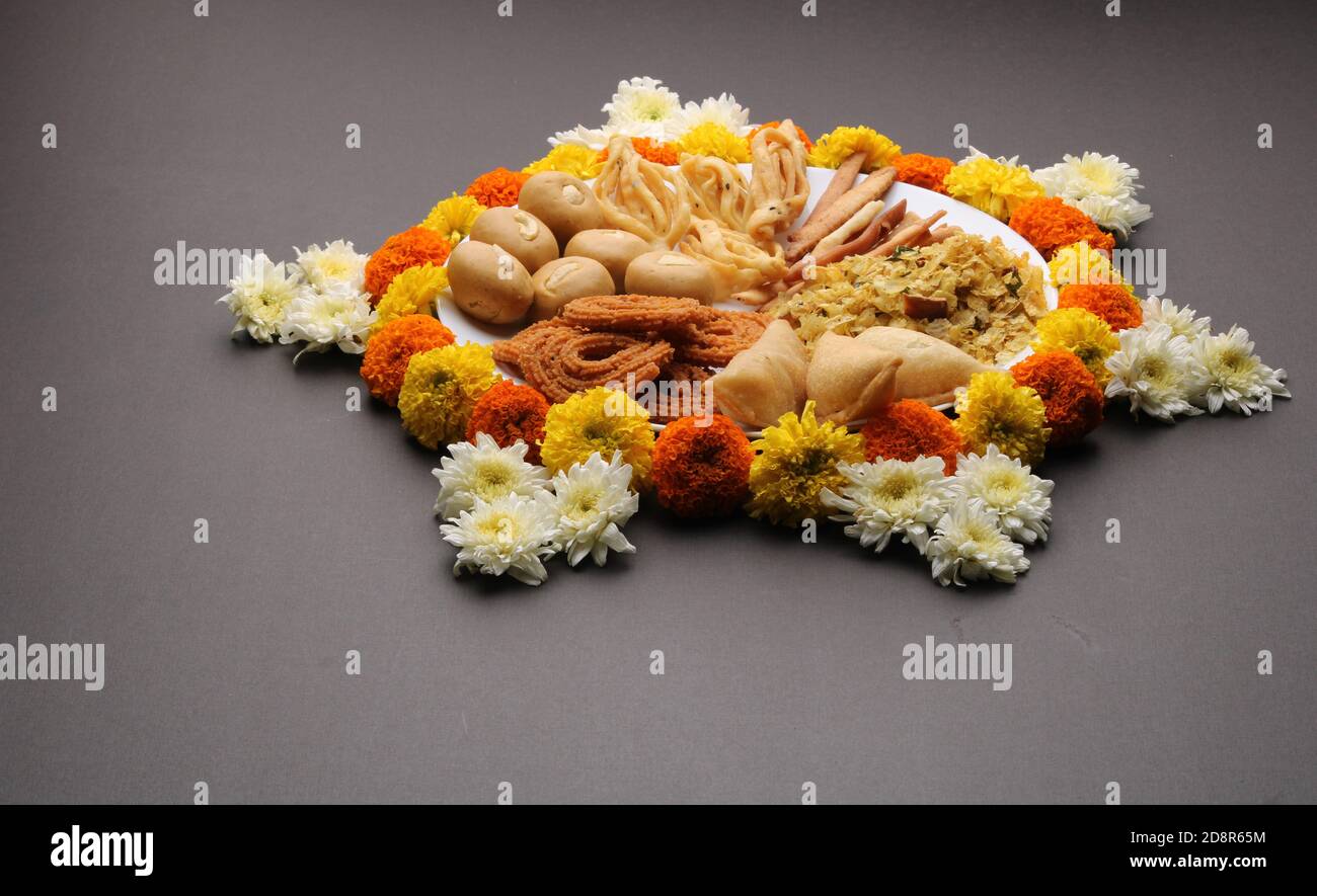 Plate full of indian festival food or diwali food or snacks like laddu, chivda, chakali or murukku and shankar pale, sweet and salty snack food. Stock Photo