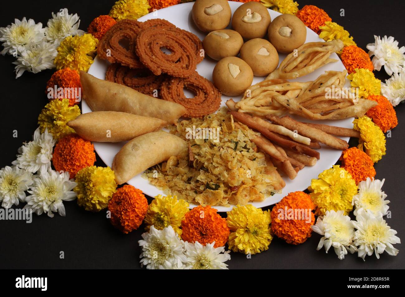 Plate full of indian festival food or diwali food or snacks like laddu,  chivda, chakali or murukku and shankar pale, sweet and salty snack food  Stock Photo - Alamy