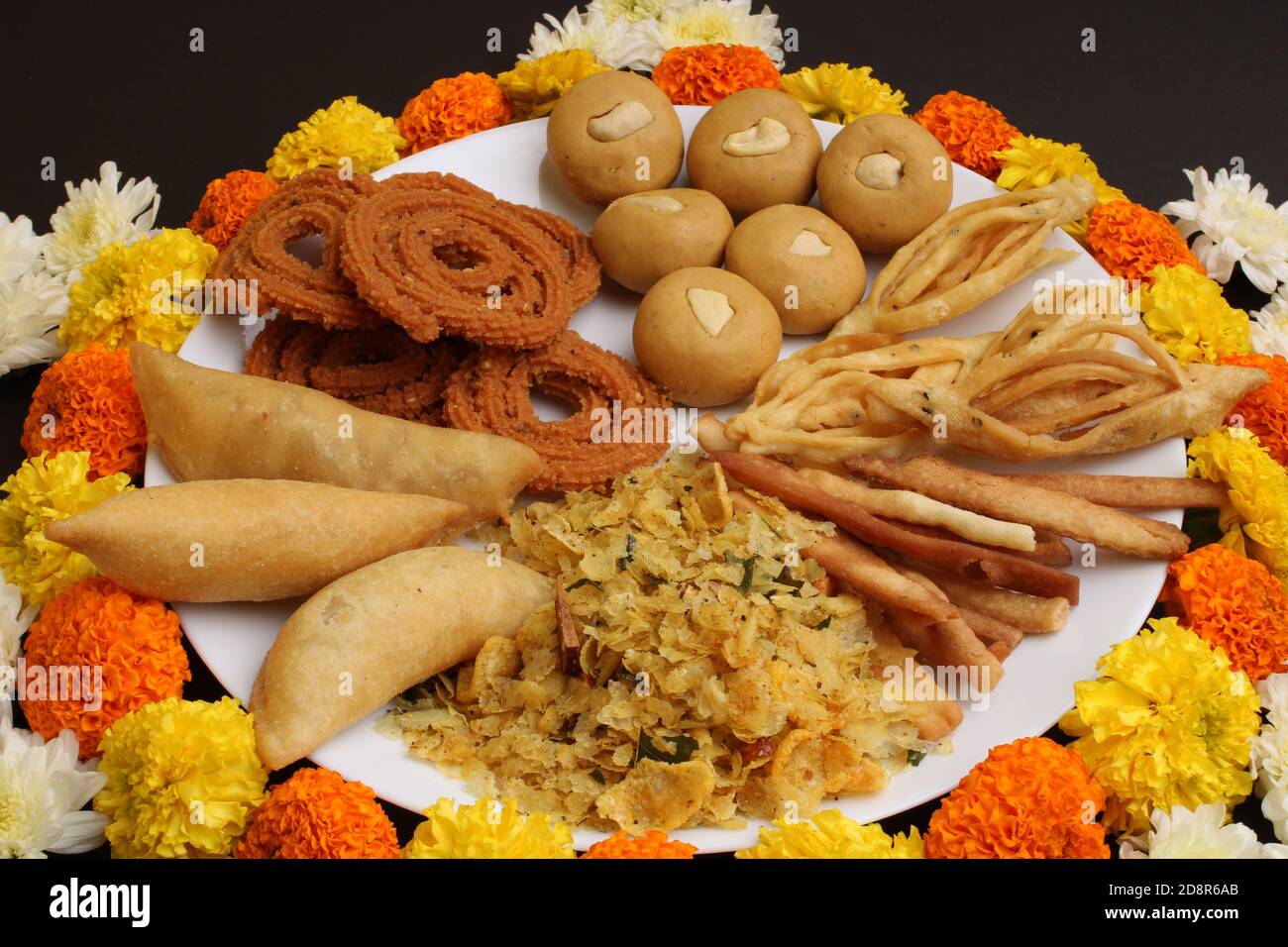 Plate full of indian festival food or diwali food or snacks like laddu, chivda, chakali or murukku and shankar pale, sweet and salty snack food. Stock Photo
