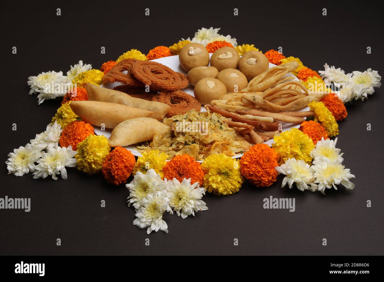 Plate full of indian festival food or diwali food or snacks like laddu, chivda, chakali or murukku and shankar pale, sweet and salty snack food. Stock Photo