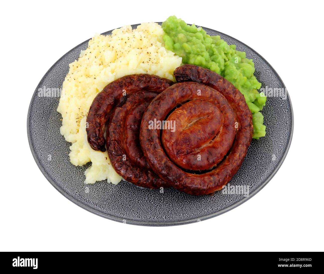 Cumberland pork sausage swirl and mashed potato meal with mushy peas isolated on a white background Stock Photo