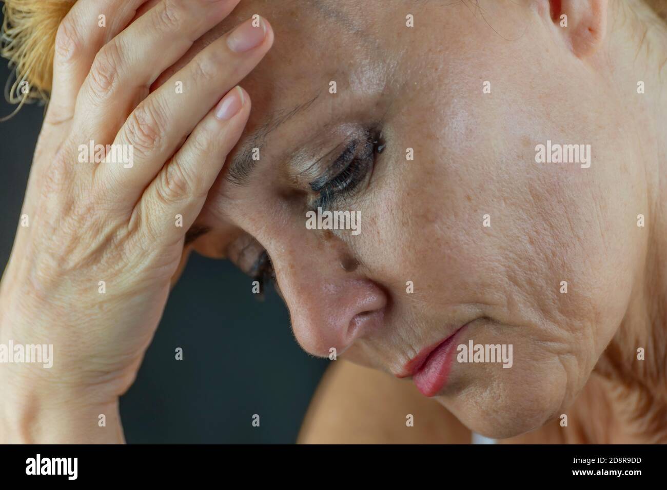 Portrait of a middle-aged white woman crying in pain and despair, with makeup running down her face Stock Photo