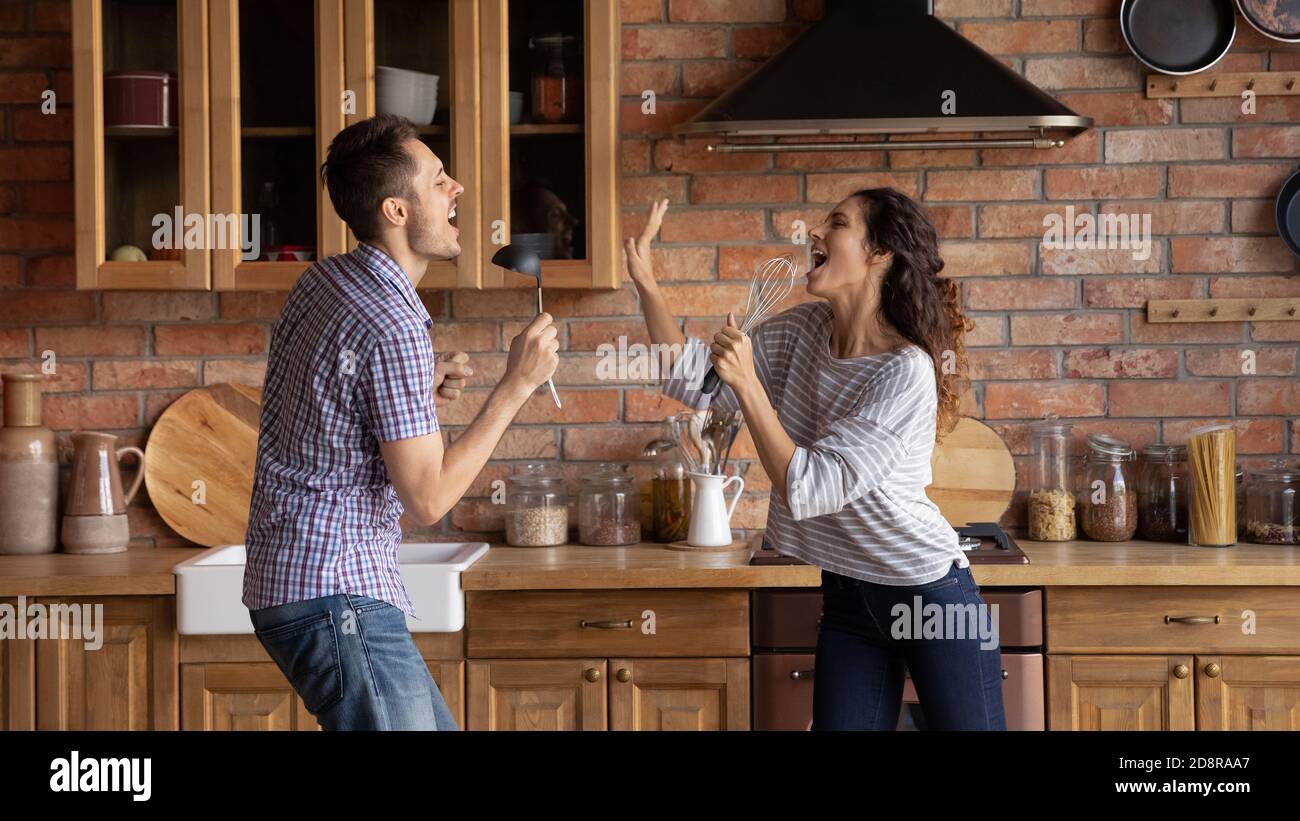 Panoramic view of happy couple have fun at home kitchen Stock Photo