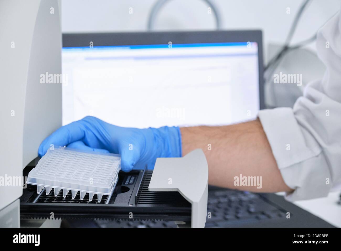 A researcher putting PCR plate on the thermal cycler for DNA