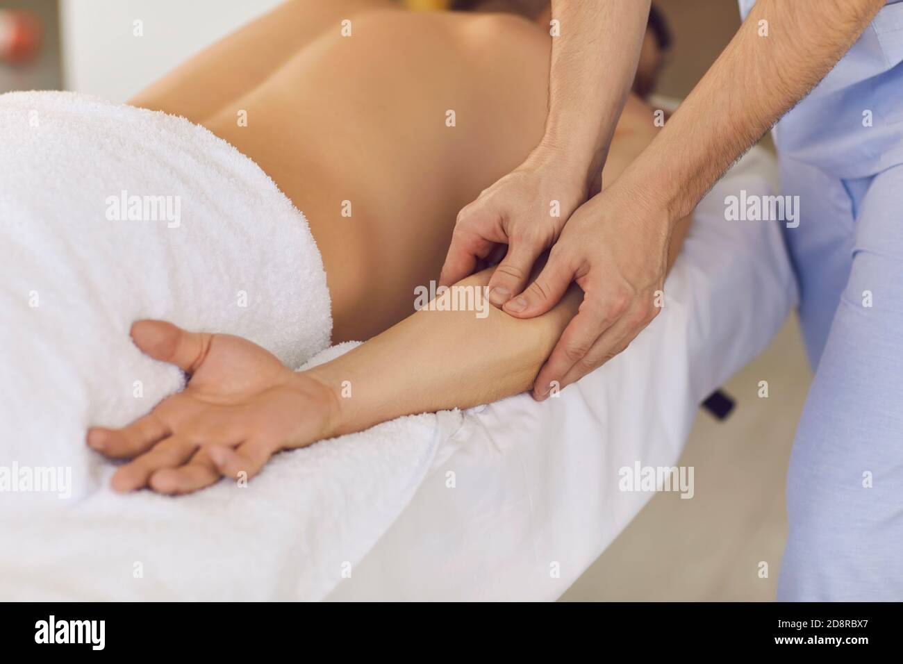 Chiropractor hands doing treatment of acupressure for mans hand Stock Photo
